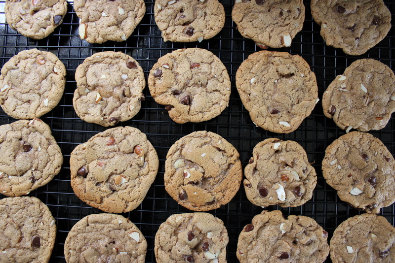 almond butter cookies with chocolate chips and almond slivers on a cooling rack