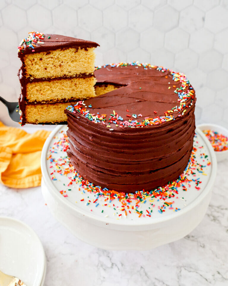 A slice of gluten free vanilla cake with chocolate buttercream