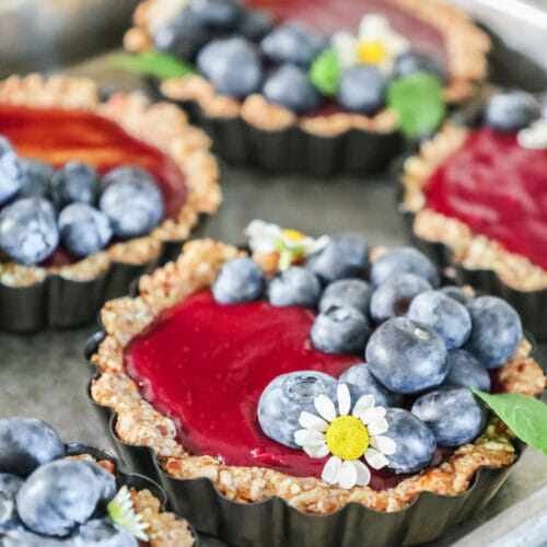 Blueberry Curd Tarts with Nut Crust in their tart pans