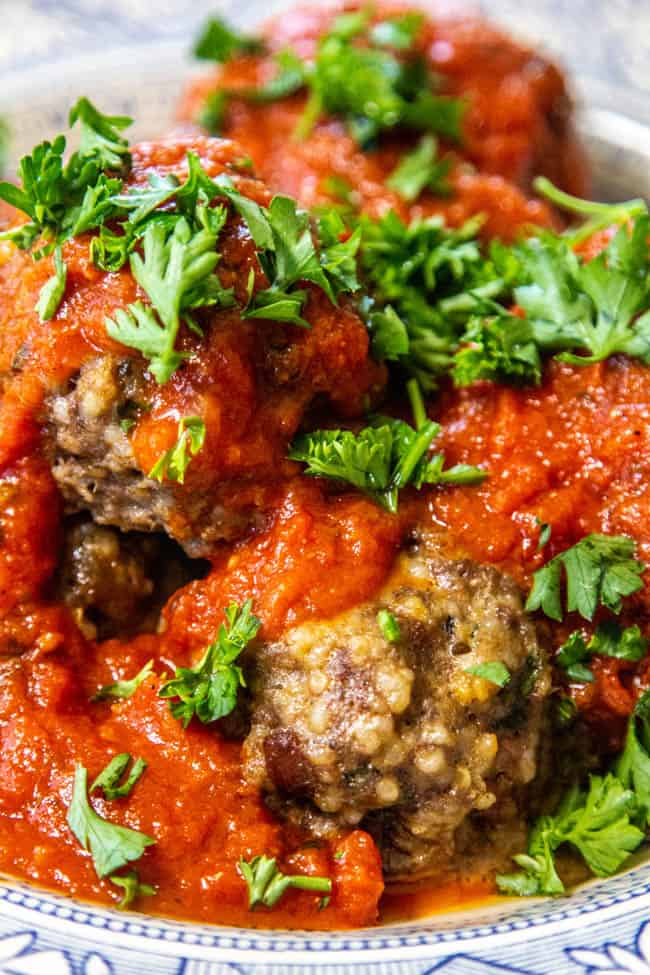 stuffed italian meatballs with red sauce garnished with parsley