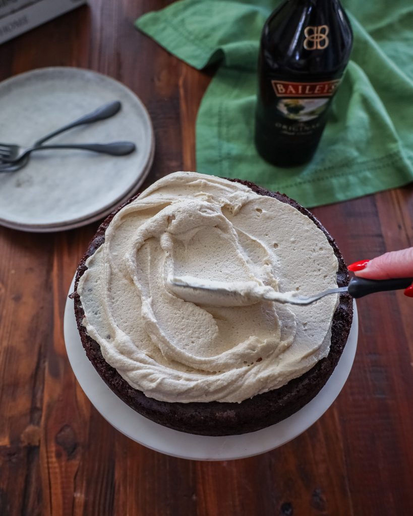 Spreading Bailey's Buttercream frosting on chocolate cake